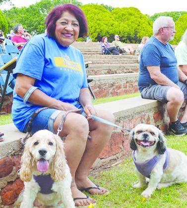 Olivia Tovar with her dogs Daisy, left, and Milo saving a spot to enjoy the concert.