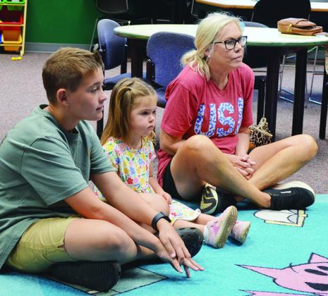 From left, Timber Hartman, Vivian Baca, and Leadell Baca listen to story time Tuesday at the Clinton Public Library. CDN | Christian Jacobsen