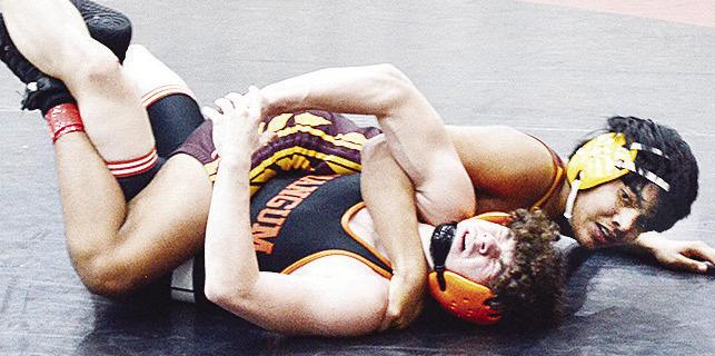 Clinton’s CJ Begay wraps himself around his opponent from Mangum in attempt to pin him during the two-day wrestling tournament in Weatherford. CDN | Sam Goodwyn
