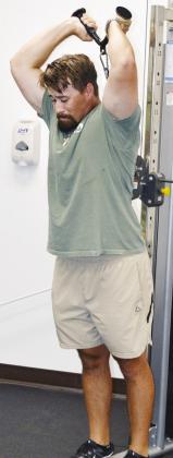 Brooks Red works on his arms by doing tricep extensions at Acme Brick Park weight room. CDN | Christian Jacobsen
