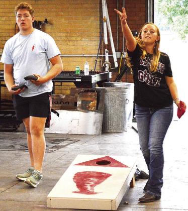 Clinton FFA students Gavin Evans, left, and Emma Ray go on a shootout in a game of cornhole during the Clinton FFA Back to School Bash Tuesday evening at Clinton High School. CDN | Micah Ashcraft
