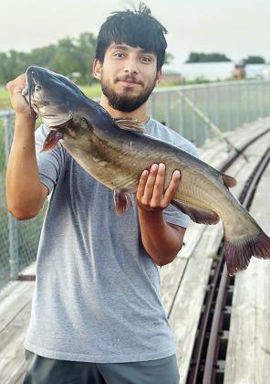 Moses Hernandez shows off his 11.35-pound catfish he caught Thursday evening at Acme Brick Park. CDN | Courtesy photo