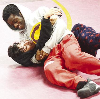 Clinton’s Marquis Martin, top, pins teammate Mathew Bermea to the mat during practice. CDN | Sam Goodwyn