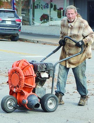 Jason Theb uses a blower to remove leaves piled up in the street Wednesday morning at the intersection of Sixth Street and Avant Avenue CDN | Micah Ashcraft