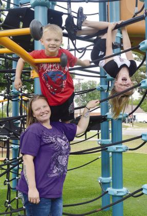 Kayla Krewall, left, watches Asher King and Dustie King climb the rope playground at McLain Rogers Park. CDN | Christian Jacobsen