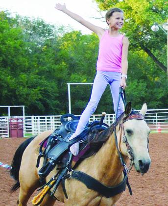 Josie Nichepor with her horse, Lizzy, practice trick riding moves Wednesday afternoon at the Clinton Rodeo Grounds. The Clinton Rodeo will take place tonight and tomorrow, with a scheduled parade at 10 a.m. tomorrow morning down Frisco Avenue. CDN | Christian Jacobsen