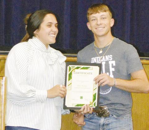 Ashlyn Hunter, left, awards Nate Hickey the Custer County 4-H Scholarship at the Arapaho-Butler Senior Awards ceremony at the auditorium. CDN | Christian Jacobsen