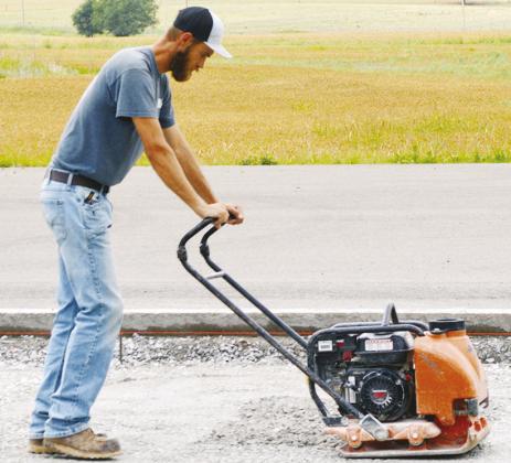 Caleb Yoder compacts the gravel in order to level the foundation and “bring it up to grade” for the future T-hangar installation at Clinton Regional Airport. CDN | Christian Jacobsen