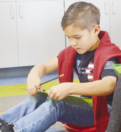 Colt Lovelace clips his worksheet into a clipboard to work on Presley Deleon follows the dotted lines while working on a his writing skills while in class at Nance Elementary School. writing assignment during class. CDN | Staff Photo