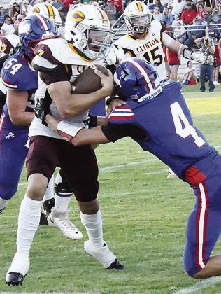 Clinton’s Easten Powell, left, fights through a would-be tackler for Chandler during the Red Tornadoes’ season-opening win Friday over the Lions on the road. CDN | John Kinsey
