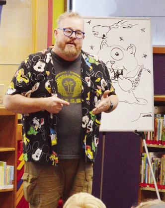 Professional storyteller Will Stuck tells the audiences a story about an alien they helped create during the WPLS Summer Reading Program’s weekly performance Wednesday at the Clinton Public Library. CDN | Micah Ashcraft