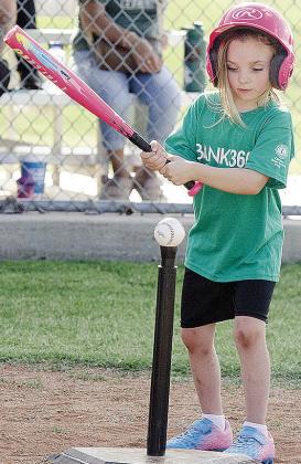 Kezli Cox focuses on the ball as she goes into her swing during her Noon Lion’s Club T-Ball game at Schumacher Fields at Acme Brick Park CDN |Sam Goodwyn