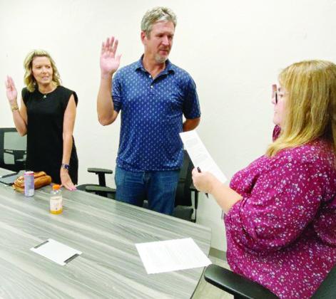 From left, Shea Meget and Luke Adams are sworn in Tuesday at the Frisco Center as trustees for the Clinton Economic Development Authority by City Clerk Amy Jones.