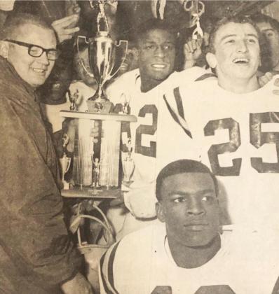 The Clinton Red Tornadoes pose with the Class A State football trophy, won by besting Wewoka 42-6 Friday night. Head coach Jim Frazier, left, grasps the trophy while, left to right from trophy, James Williams, E.L. Jefferson, Myron Hines and Chuck Powell 