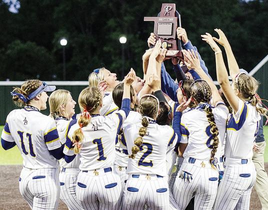 The Arapaho-Butler Lady Indians slow-pitch softball team surrounds Principal Jared Cudd, as he raises the Class 3A State Championship Trophy following the team’s 13-2 win over Caddo Wednesday at the FireLake Ball Fields. CDN | Sam Goodwyn