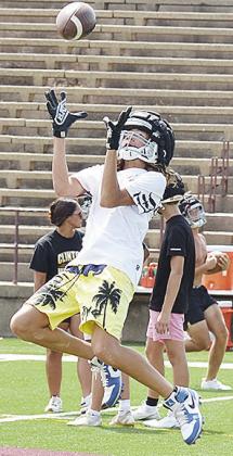 Clinton’s Dadrian Hester soars through the air as he goes for the ball during the first day of football practice Monday in the Tornado Bowl. CDN | Sam Goodwyn