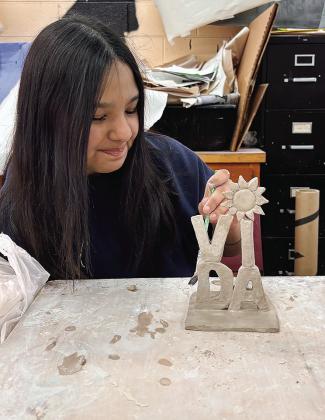 Omelda Lovos works on her clay miniature word sculpture at Clinton High School. Her class made them as a tribute to Robert Indiana’s Love sculpture. CDN | Courtesy photo