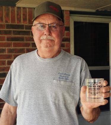 Randy Kelley shows off his new gifted retirement glass. The text reads, “Every sip tastes like it’s not my problem anymore. Retired 2026.” CDN | Christian Jacobsen