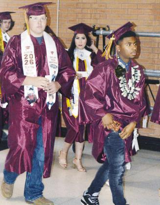 From left, Dylan Hoffman, Danna Mendieta and Derren Hester walk toward their graduation ceremony at the Tornado Dome. CDN | Christian Jacobsen