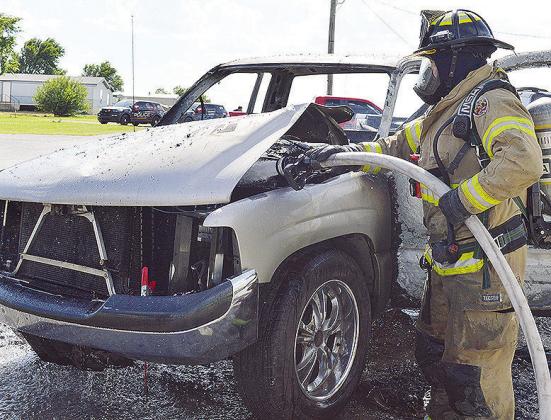 Firefighter Austin Long hoses down an engine after a truck fire recently at Petty Lane. CDN | Micah Ashcraft