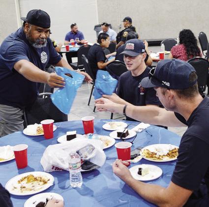 From left, Emergency Management Dir. Charles Black hands out goodie bags to Colten Helms, and Lt. Billy Gerstenkorn Monday at the Hometown Heroes Luncheon hosted by Lucky Star Casino at the Frisco Center. CDN | Christian Jacobsen