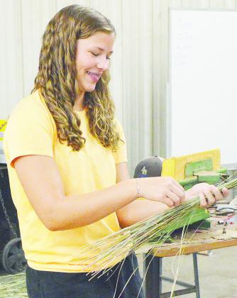 Arapaho-Butler’s Georgia Rose works to bundle together straws of grass during her agriculture class Monday morning. CDN | Micah Ashcraft