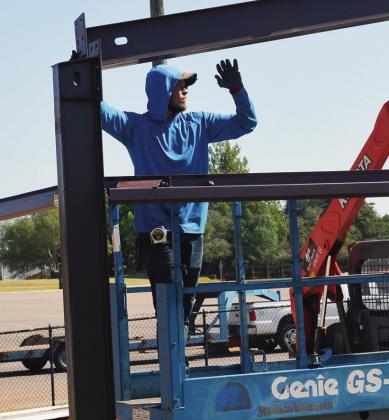 Drake Carnes lines up the frame of the new equipment shed Tuesday at Clinton High School near the weight room and track. CDN | Christian Jacobsen