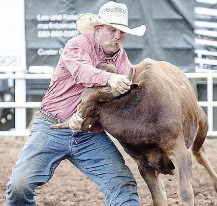 Hunter Washburn wrestles the steer during the rodeo Saturday at the Clinton Round-Up Club Arena. CDN | Sam Goodwyn