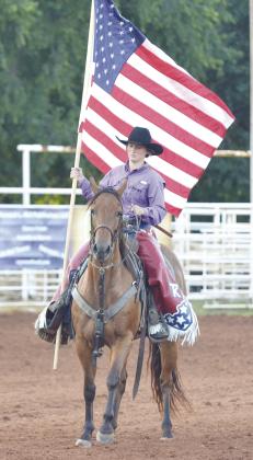 Shelby Mitchell carries the flag prior to the second day of the Clinton Round-Up Club Rodeo Saturday evening at the Roundup Club Arena. CDN | Sam Goodwyn