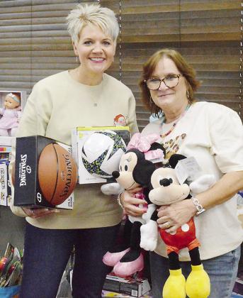 Clinton Public Schools Activity Fund Director Natalie Blundell, left, and Clinton Public School Foundation Co-Director Tonya Gaunt add more toys to the pile to be donated to the Clinton Christmas Connection during Clinton Public Schools’ annual Stipend 