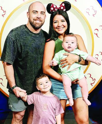 Newly hired Clinton boys’ wrestling coach Matt Kennedy, left, holds his son Koe’s hand, and his wife Denise, right, holds their infant Cub while at Disney. CDN | Courtesy photo