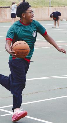 Omar Calixto runs up to the basket during a two-on-two game Tuesday afternoon at the McLain Rogers Park basketball court. CDN | Christian Jacobson