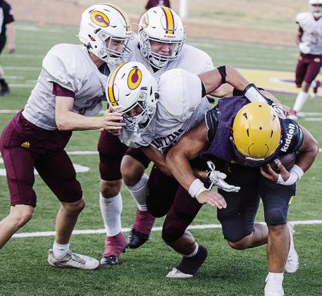 Clinton’s JJ Ruiz, front, wraps up the Anadarko ball carrier with help from Judd Hall, left, and Easten Powell, back, during the Red Tornadoes’ scrimmage against Anadarko. CDN | Sam Goodwyn