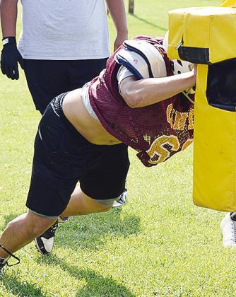 Colton Pool works on his blocking technique with the sled dummies during practice. CDN | Sam Goodwyn