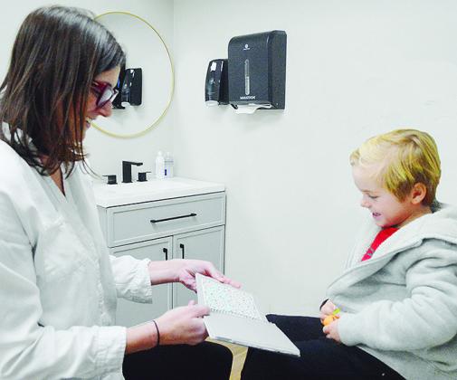 Dr. Randi Day, left, gives Robert Cornell a test during his routine eye exam at Peek Eyecare. CDN | Micah Ashcraft