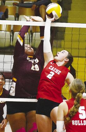 Clinton’s Aracelie Chavez, left, goes up to block a Cache player during the Lady Reds’ match against the Lady Bulldogs at the Tornado Dome. CDN | Sam Goodwyn