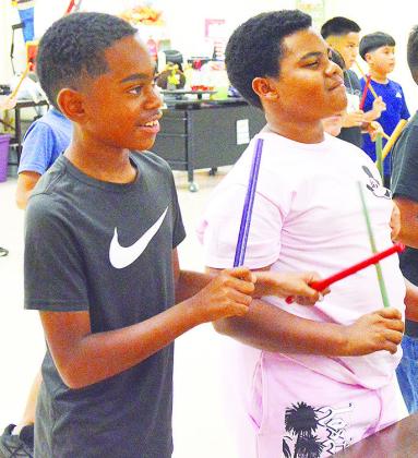 Amari Reed, left, and JaMarley Littleton feel the groove while they take part in a singing and dancing activity during music class at Southwest Elementary. CDN | Micah Ashcraft