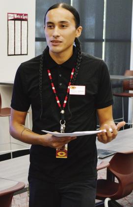 Ahk-ta-na-hi Goodblanket passes out worksheet packets at CMS. CDN | Christian Jacobsen