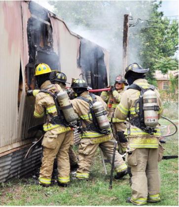 Fire gutted this trailer friday afternoon located at 1717 Hunt Ave. Here, from left, Lt. Tyler Calvert, Zach Lustfield, Ronnie Williams and Billy Gerstenkorn work to make sure all of the embers are snuffed out. CDN | Staff Photo