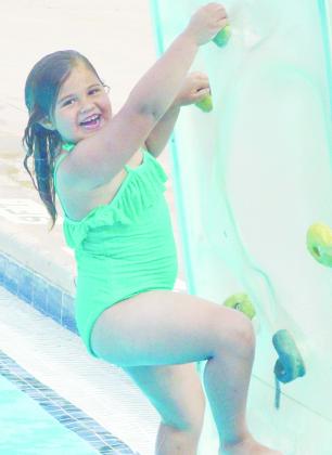 Tinlee Roper climbs the rock wall at the Clinton Pool. CDN | Christian Jacobsen