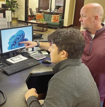 Intern Sutton Hernandez, left, observes as Chris Jones from Bank 360 guides him through several certification learning modules. CDN | Shiann Dawson