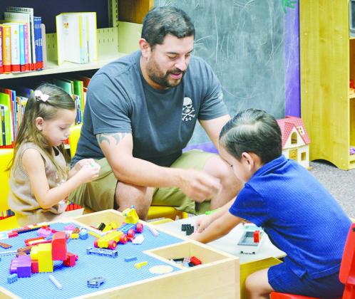 Building LEGO cars and ships together are, from left, Emily, Frank, and Brandt Casas at the Clinton Public Library. CDN | Christian Jacobsen