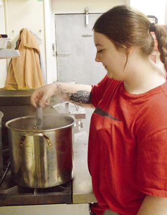 Cook Abbey Shields stirs up a pot of ground beef while preparing a meal for people in her new role helming the kitchen of the Clinton Mission House. CDN | Micah Ashcraft