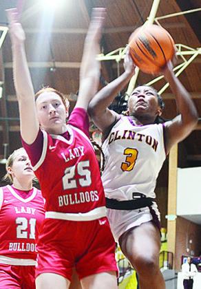 Clinton’s Arlena Kirkendoll battles against a defender as she goes up for the layup in the Lady Reds’ win over Cache. CDN | Sam Goodwyn