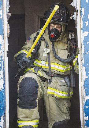 Clinton firefighter Collin Wieder climbs through the window during training at the Mission House.