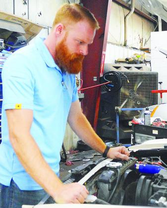 Jake Gutermuth looks under the hood of a customer’s vehicle at McKinsey Motors. CDN | Micah Ashcraft