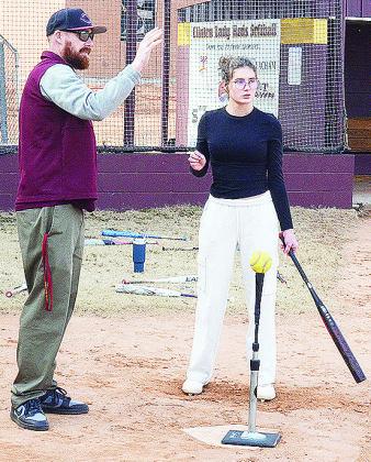 Clinton’s new softball coach Michael Deatherage, left, instructs Reese Giblet through a hitting exercise. CDN | Sam Goodwyn