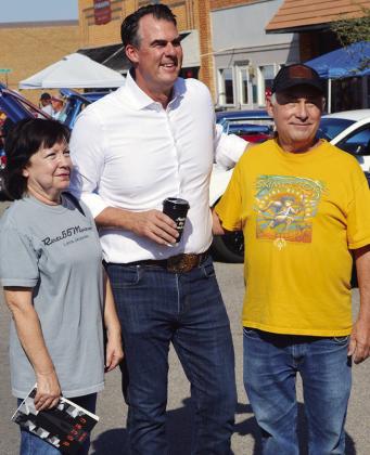 From left, Beth Dewees, Gov. Kevin Stitt, and Kent Dewees pose for a picture Saturday at the Centennial Lap event on Frisco Avenue. CDN | Christian Jacobsen