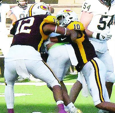 No. 12 Aaron Ramirez, left, and No. 10 JJ Ruiz combine to take down the Heritage Hall ball carrier during the Red Tornadoes’ season opener against the Chargers Friday in the Tornado Bowl. CDN | John Kinsey