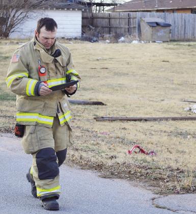 Clinton Firefighter Jacob Hoffman records evidence of damage while at the scene of three fallen utility poles Monday afternoon near the 900 block of N. 17th Street. CDN | Micah Ashcraft
